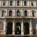 Il piano terra  rivestito da un bugnato levigato, mentre l'entrata presenta tre cancellate in ferro ad arco a tutto sesto, incorniciate da quattro colonne ioniche che sostengono l'elegante balcone del primo piano